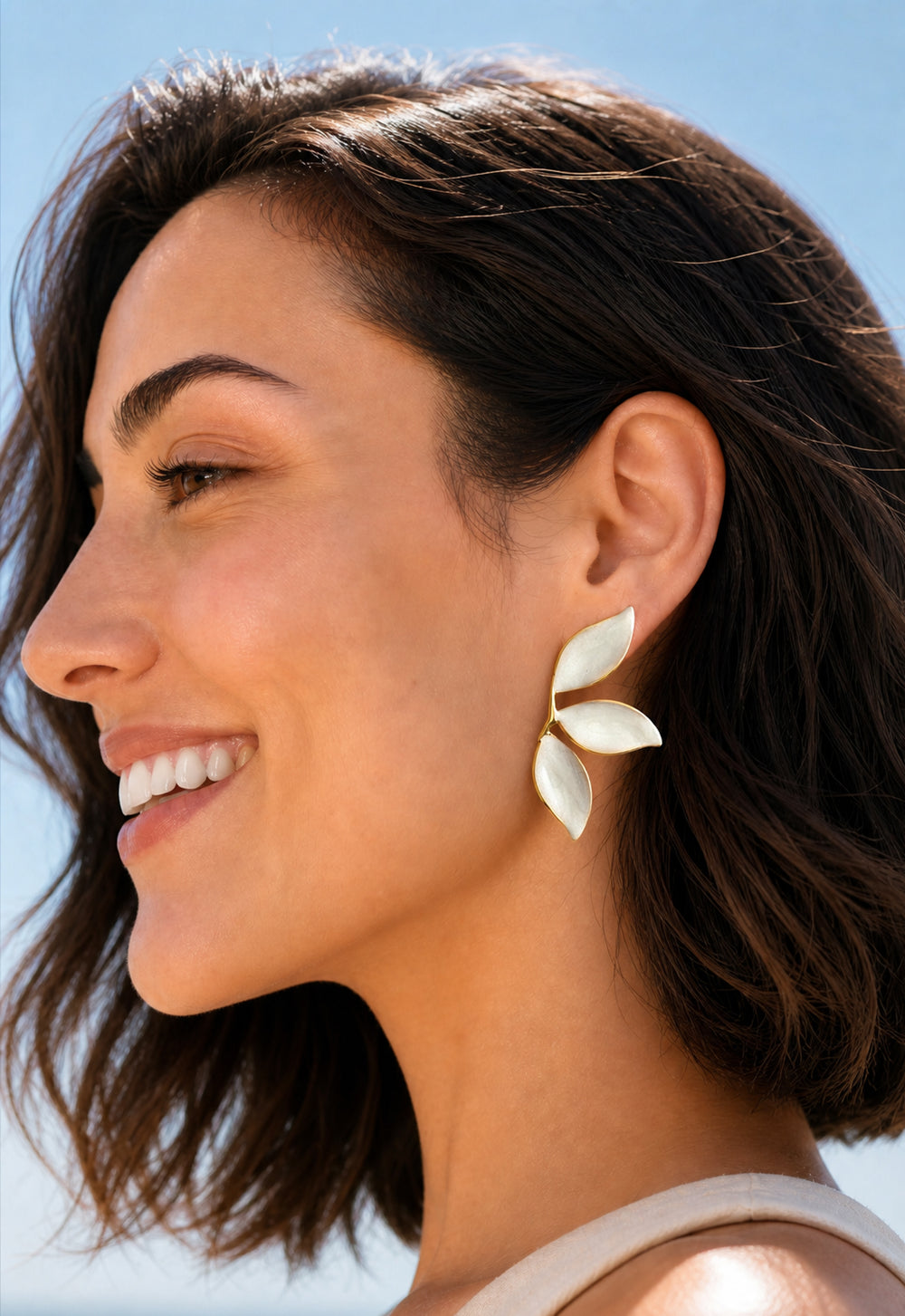 Profile of smiling model wearing Canopy pearl white leaf earrings