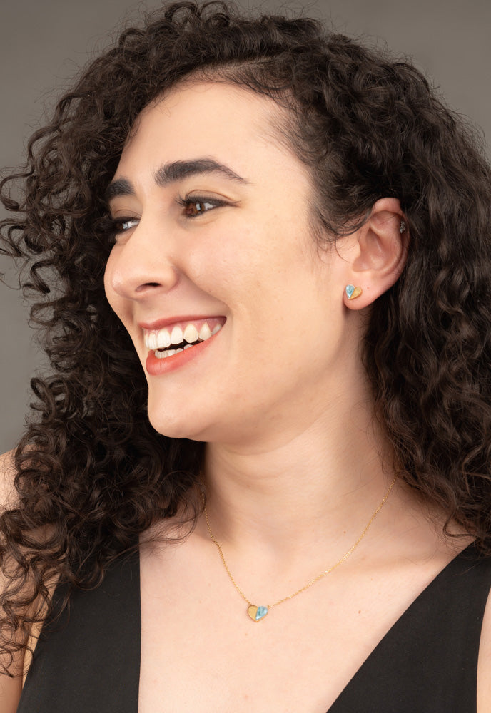 Laughing model wearing Give Hope mint heart stud earrings and matching heart necklace