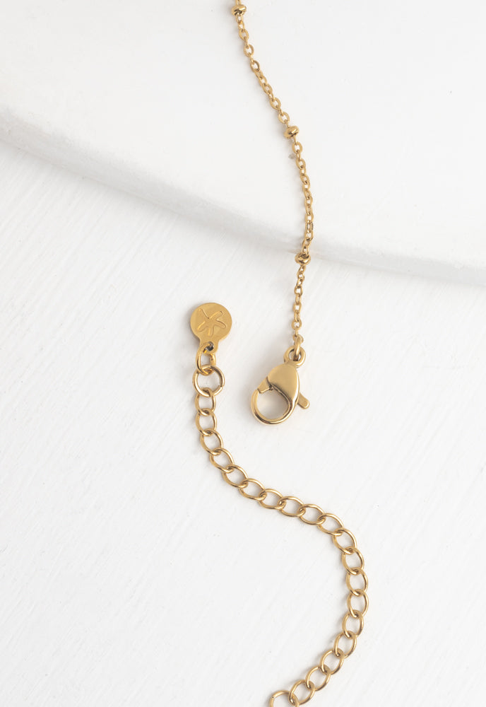 Close-up of gold bar necklace lobster clasp, extender and Starfish Project logo tag
