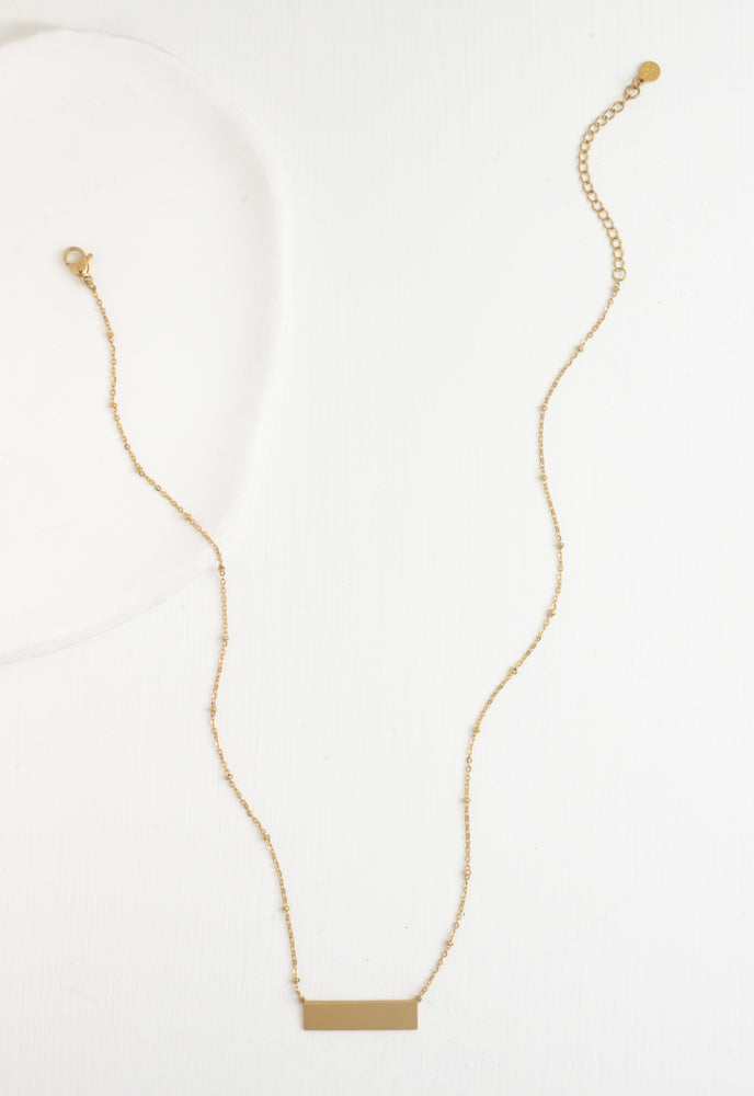 Engravable gold bar necklace beaded satellite chain laid out full length
