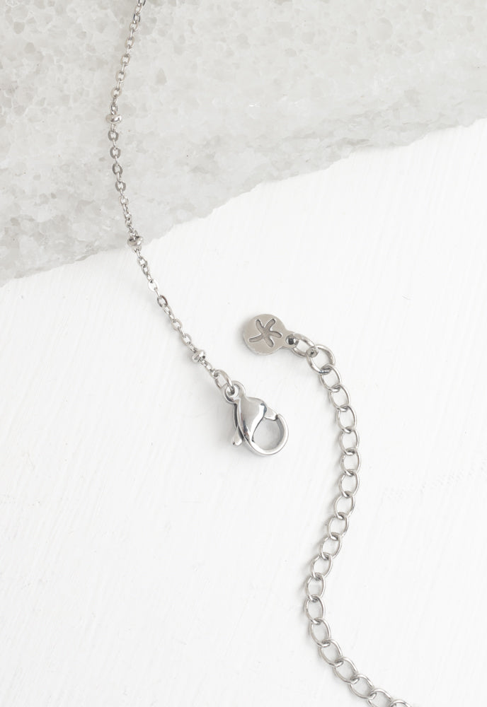 Close-up of silver bar necklace lobster clasp, extender, and Starfish Project logo tag