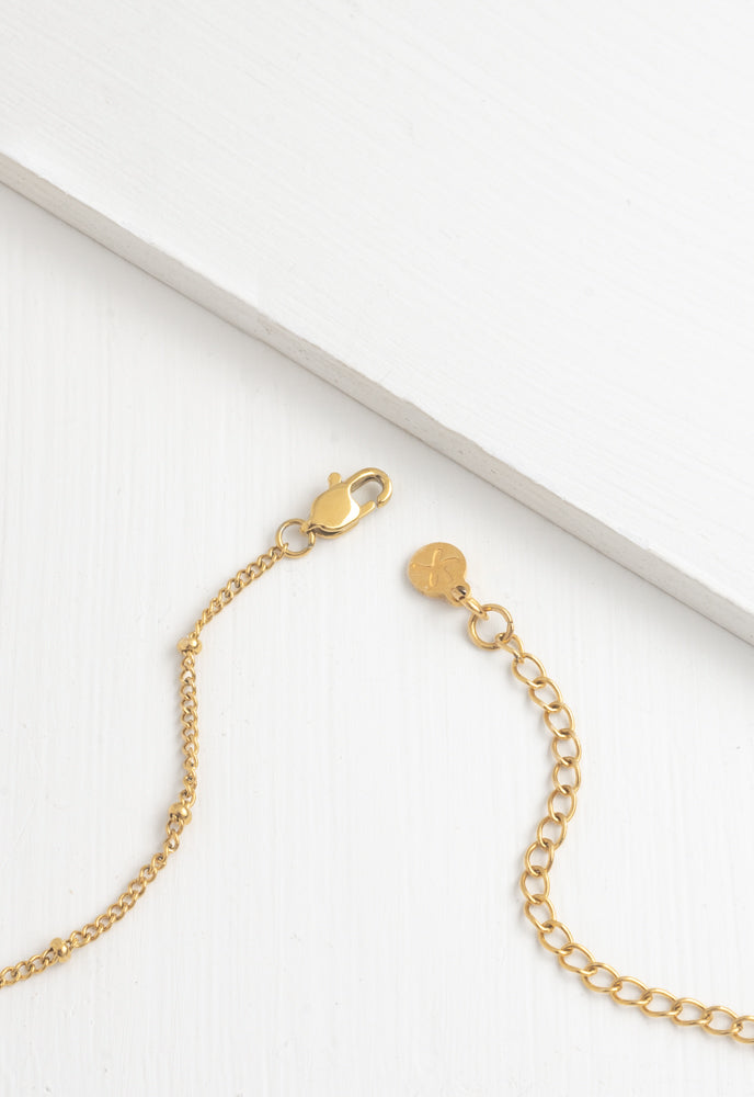 Close-up of Engravable necklace gold lobster clasp, extender and logo tag