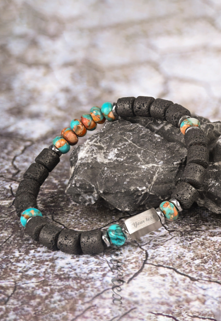 Strength bracelet with engraved steel bar draped over a gray stone