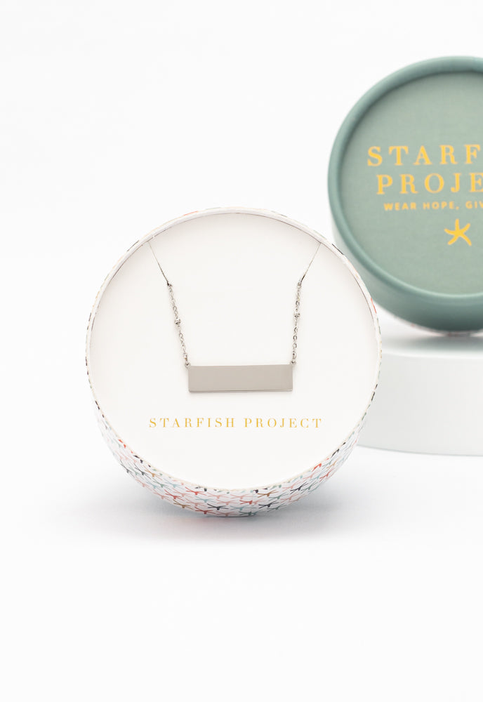 Engravable silver bar necklace in a Starfish Project round gift box